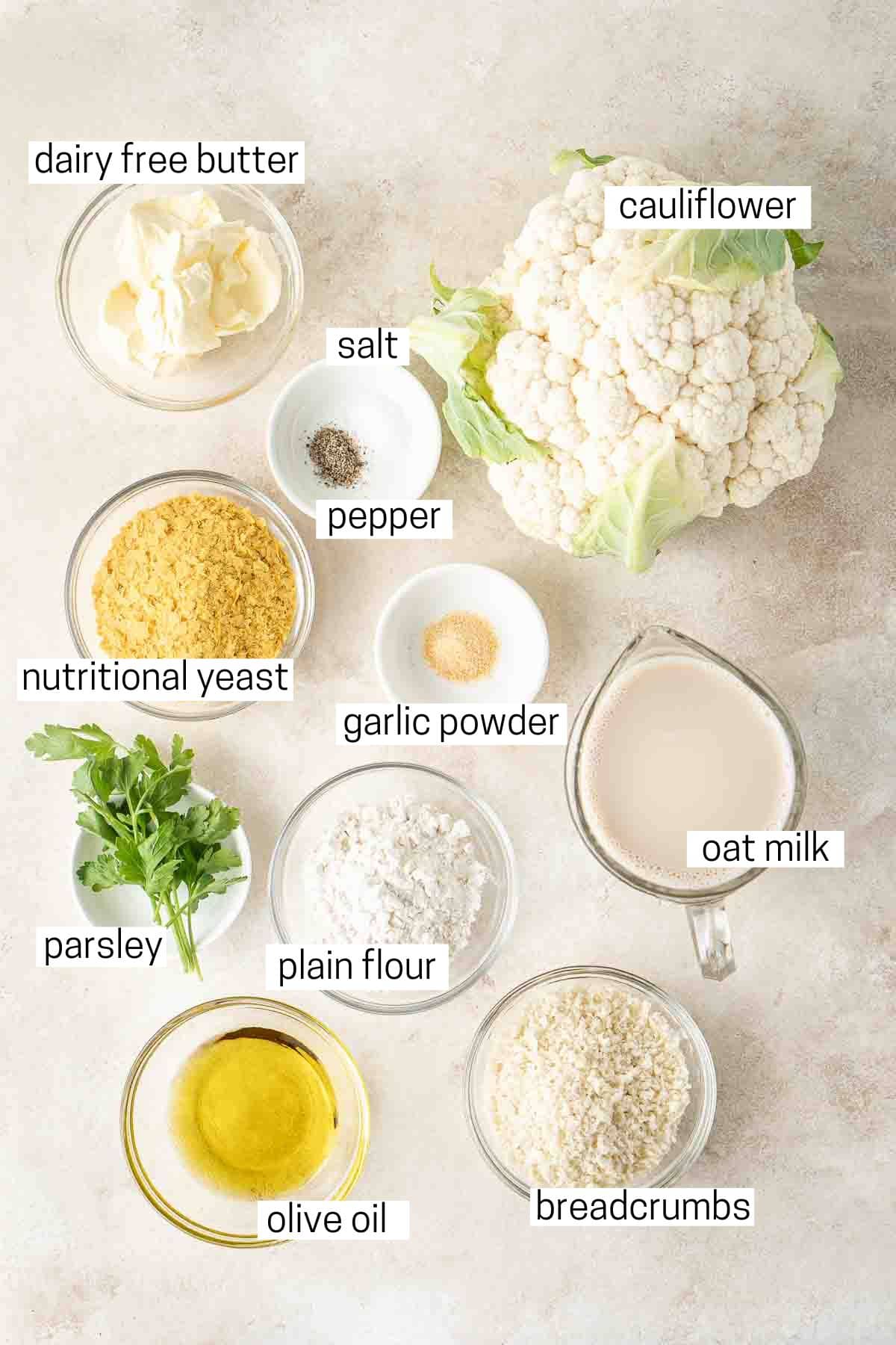 All ingredients needed for vegan cauliflower bake laid out in small bowls.