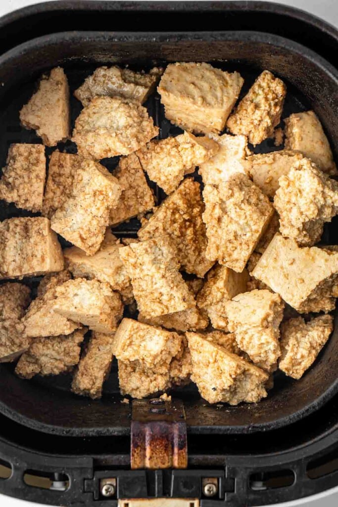 Tofu in the air fryer basket ready be cooked.