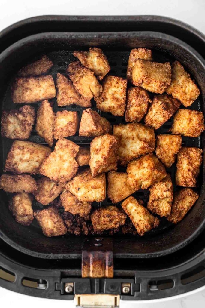 Crispy tofu in air fryer basket.