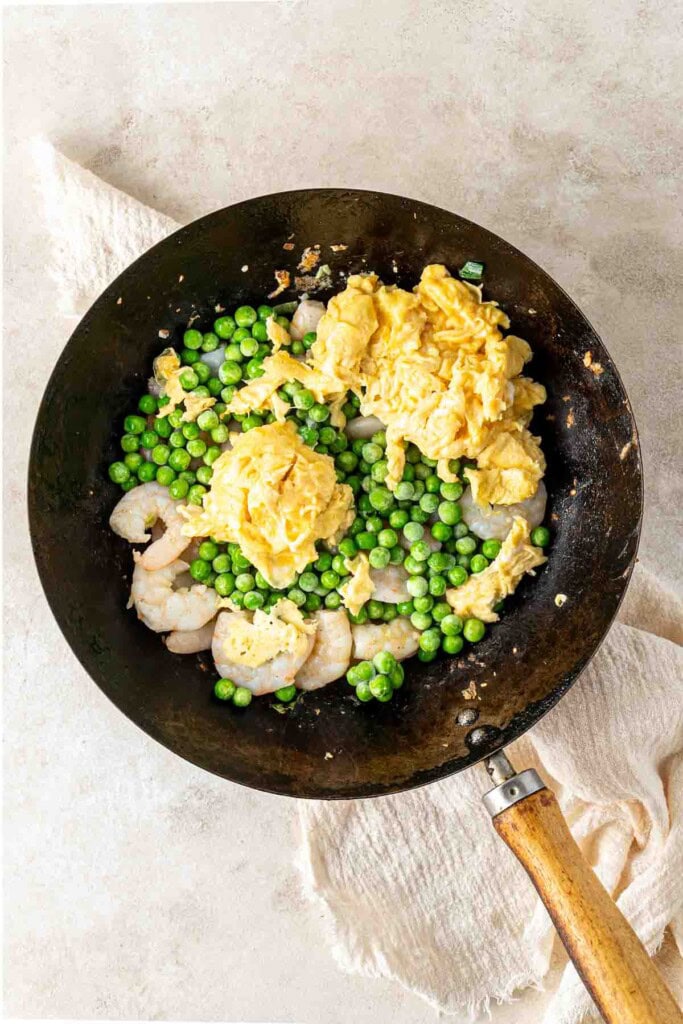 Prawns, peas and eggs in a wok.