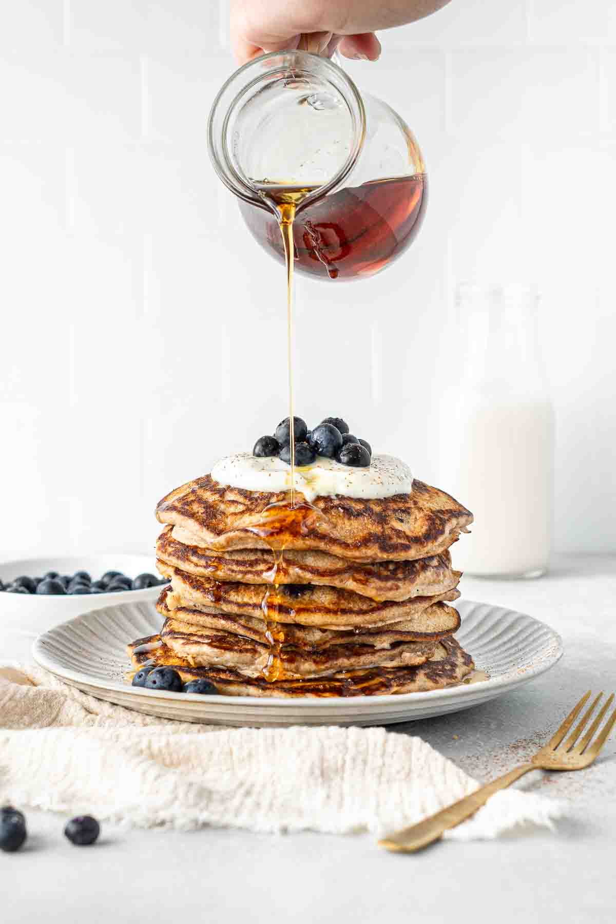Drizzling maple syrup over blueberry buttermilk pancakes.