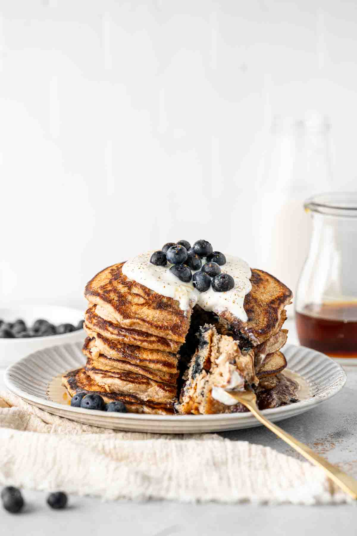 Stack of dairy free blueberry pancakes with a bite taken.