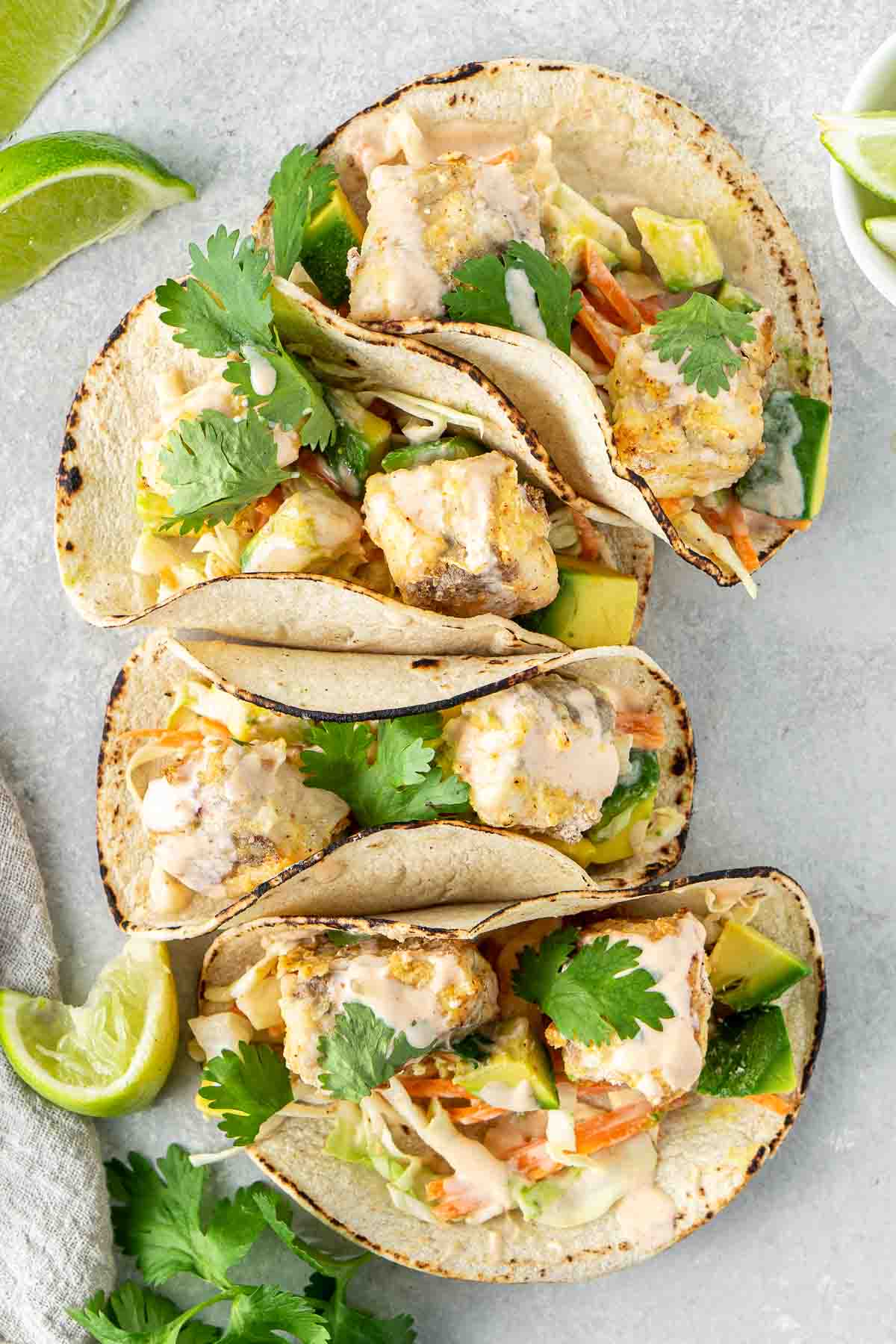 Gluten free fish tacos laid out with lime and coriander. 
