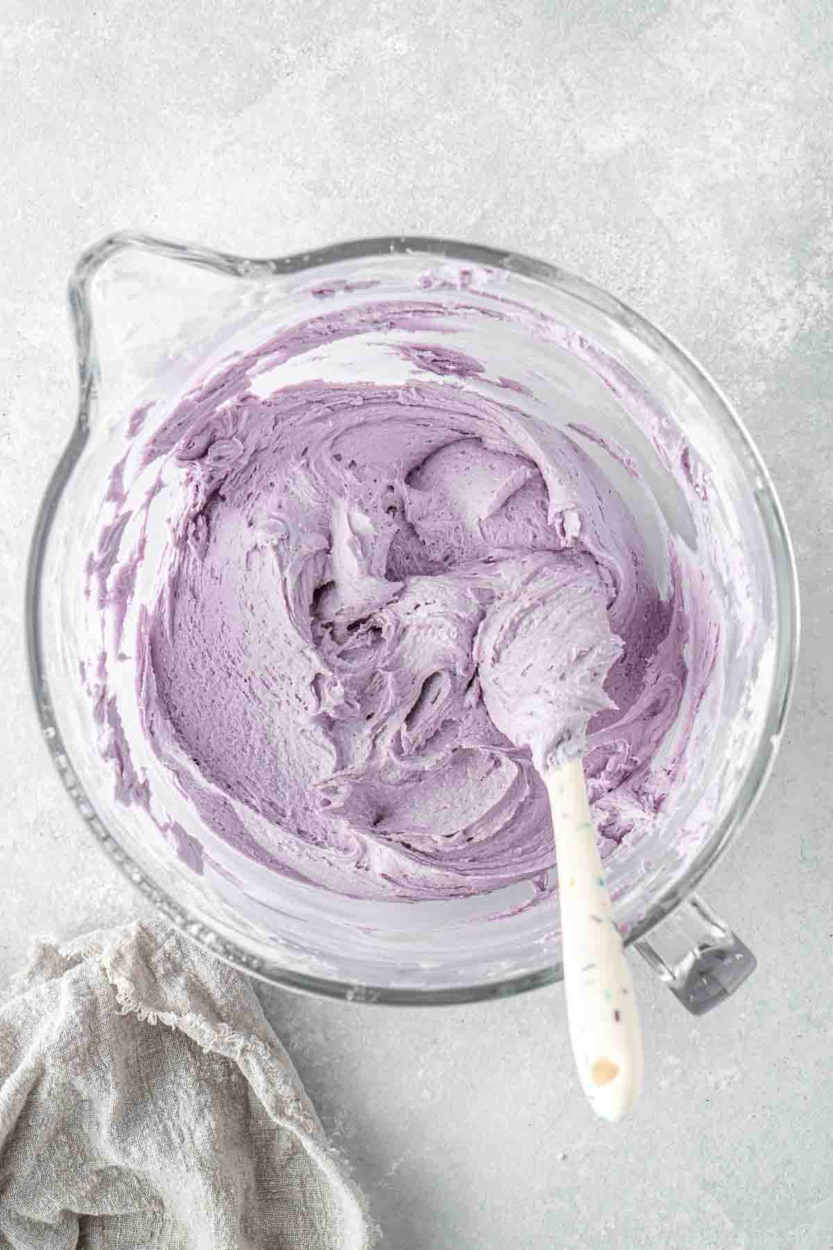 Vegan lavender buttercream in a mixing bowl with a spatula. 