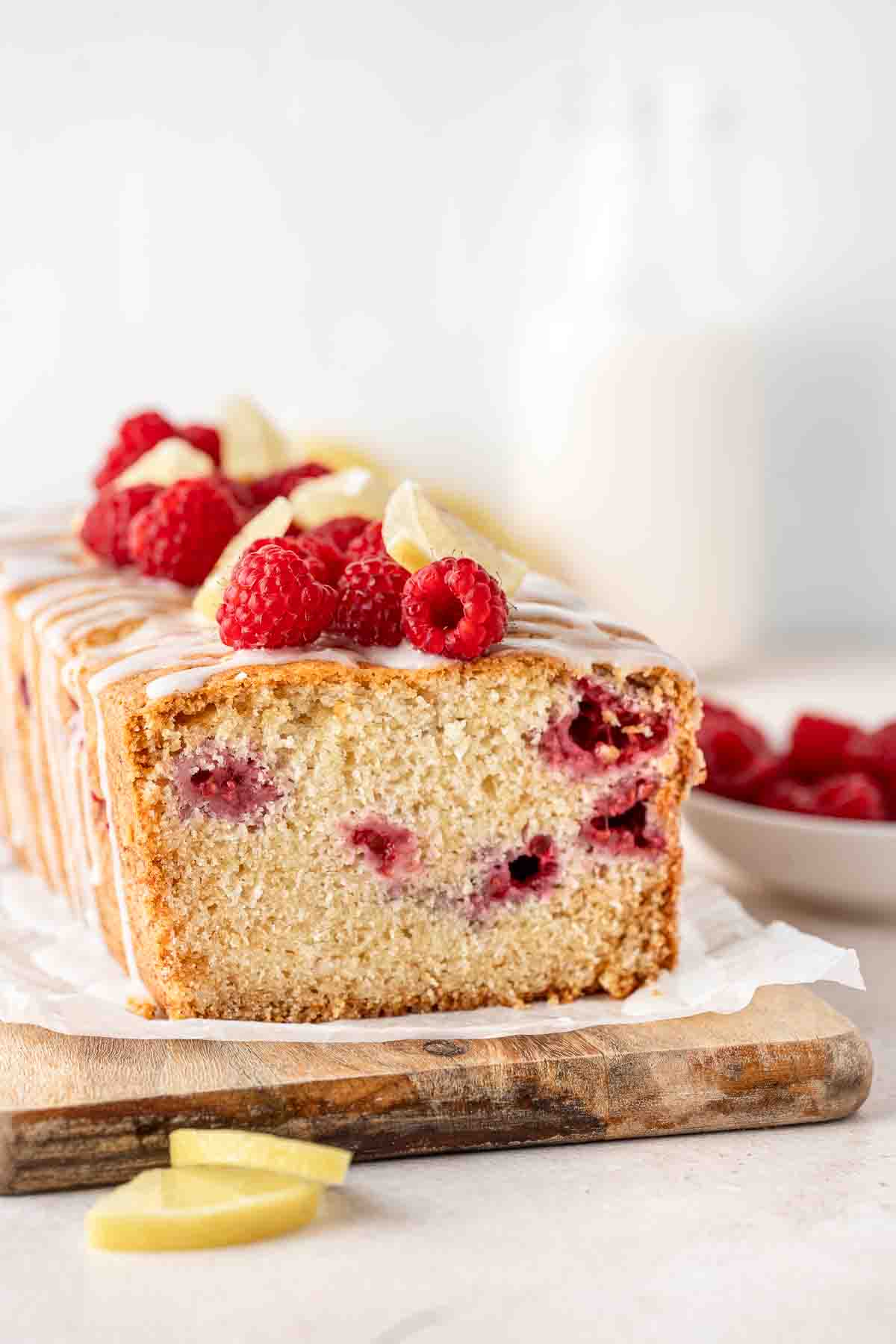 Close up of the sliced lemon and raspberry cake with raspberries on top.