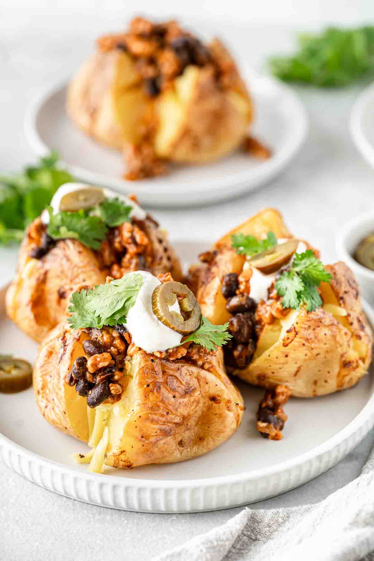 Three Mexican-style loaded potatoes on a plate.
