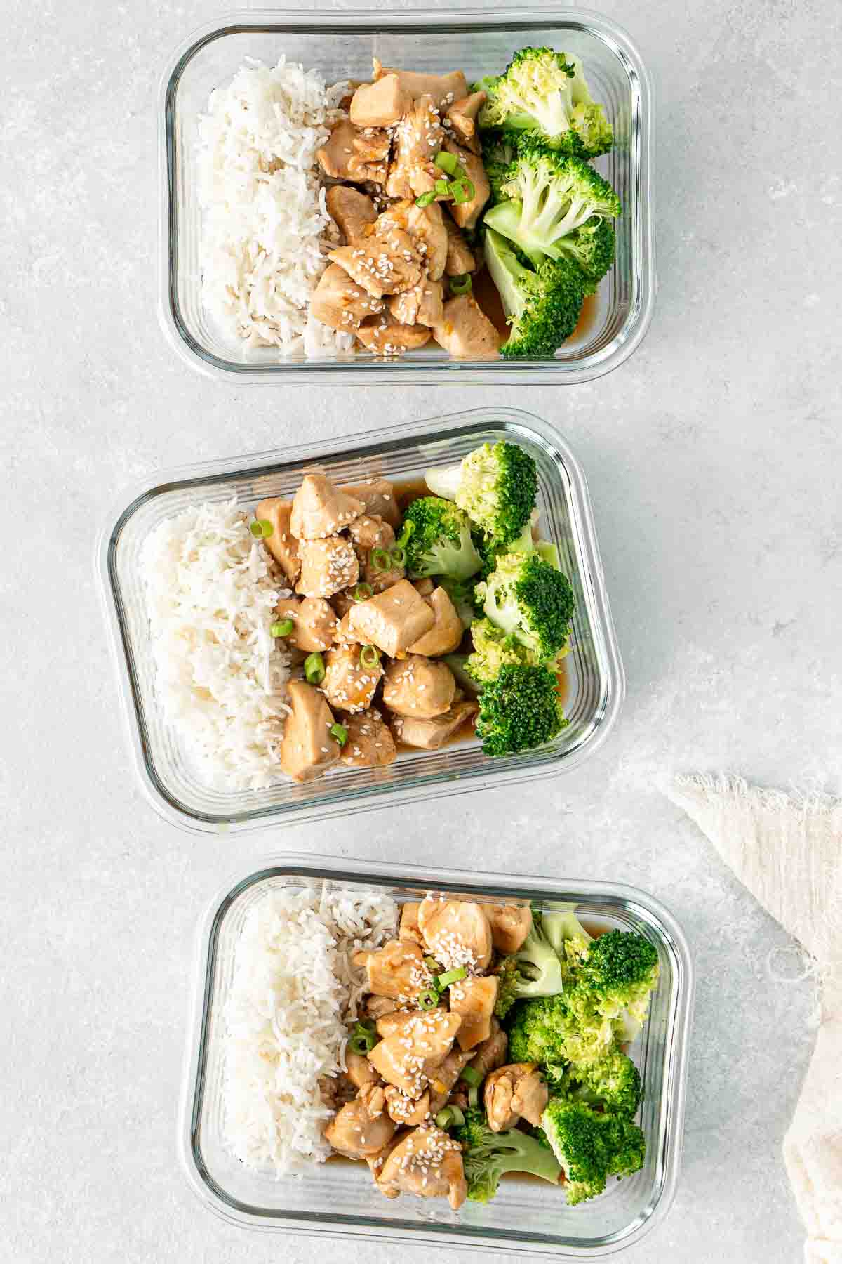 Three containers of Teriyaki chicken, broccoli and rice.