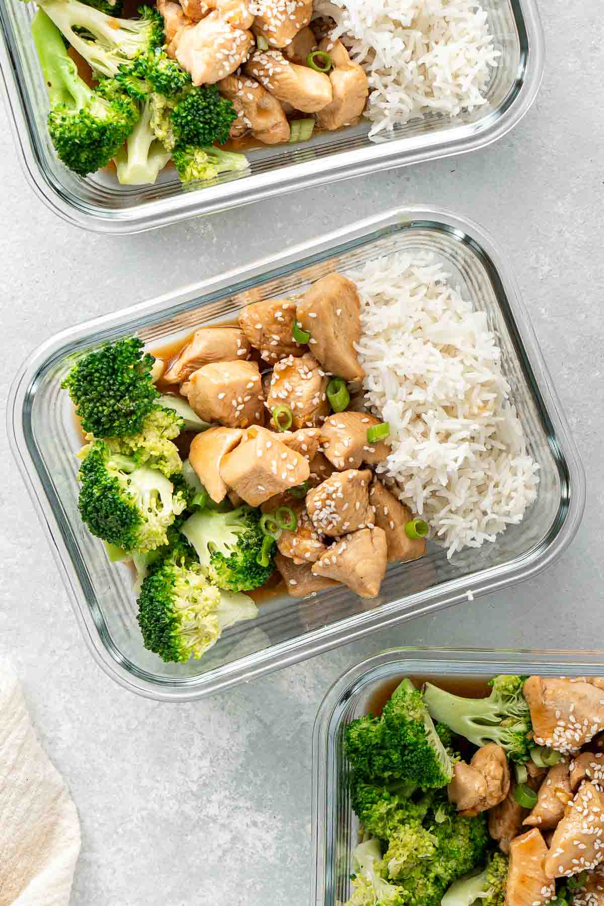 Teriyaki chicken, broccoli and rice in meal prep containers with spring onion and sesame seeds. 