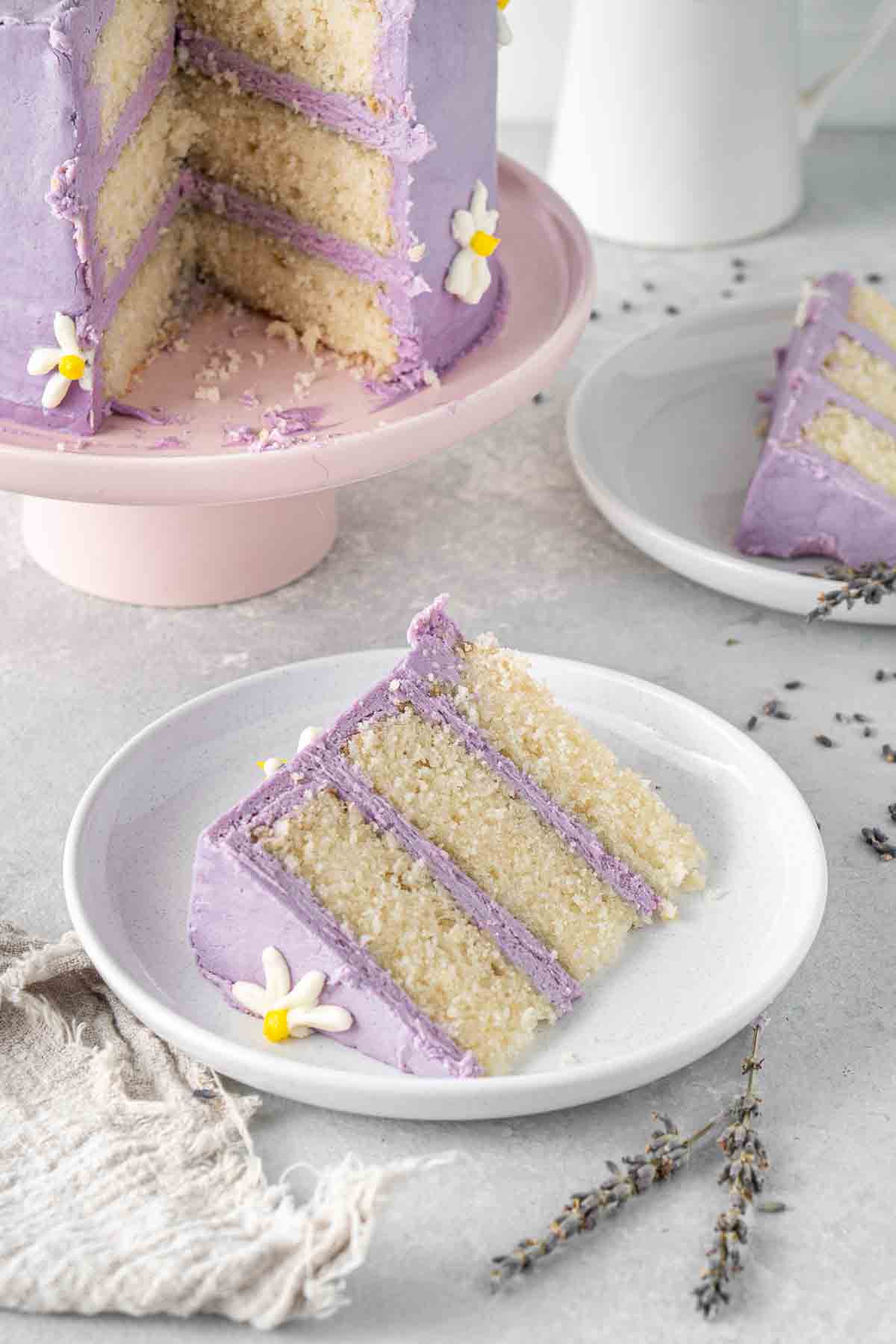 A slice of vegan lemon cake with lavender buttercream.