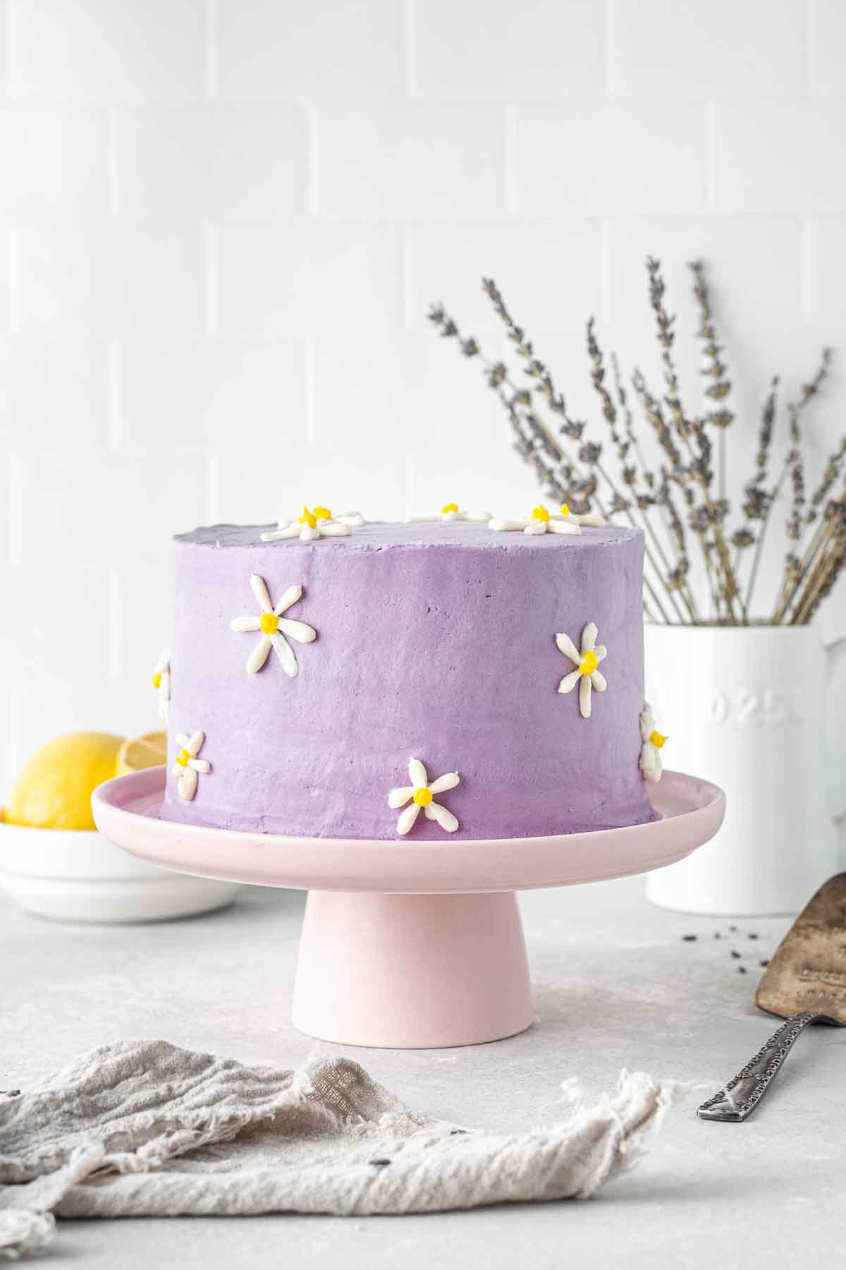 Decorated daisy cake on a cake stand.
