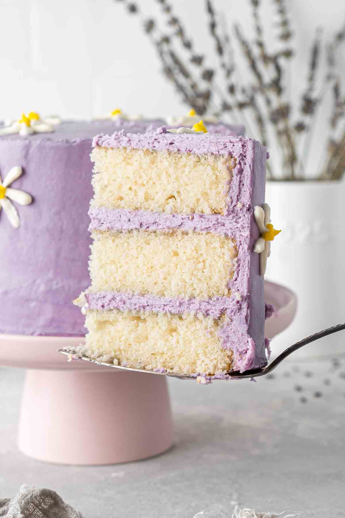 A slice of vegan lemon cake with lavender buttercream.
