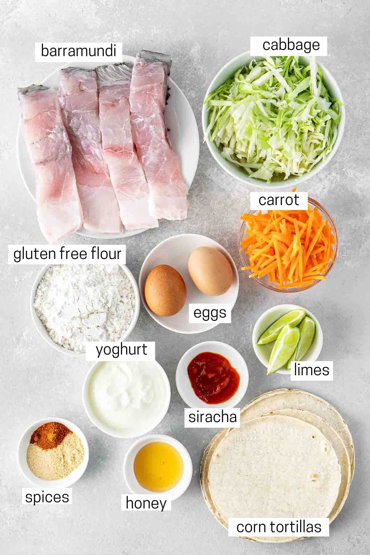 All ingredients needed for fish tacos laid out in small bowls.