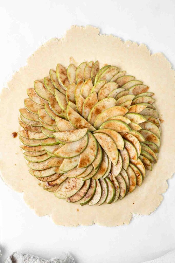 Laying out the apple slices on the rolled out pastry.