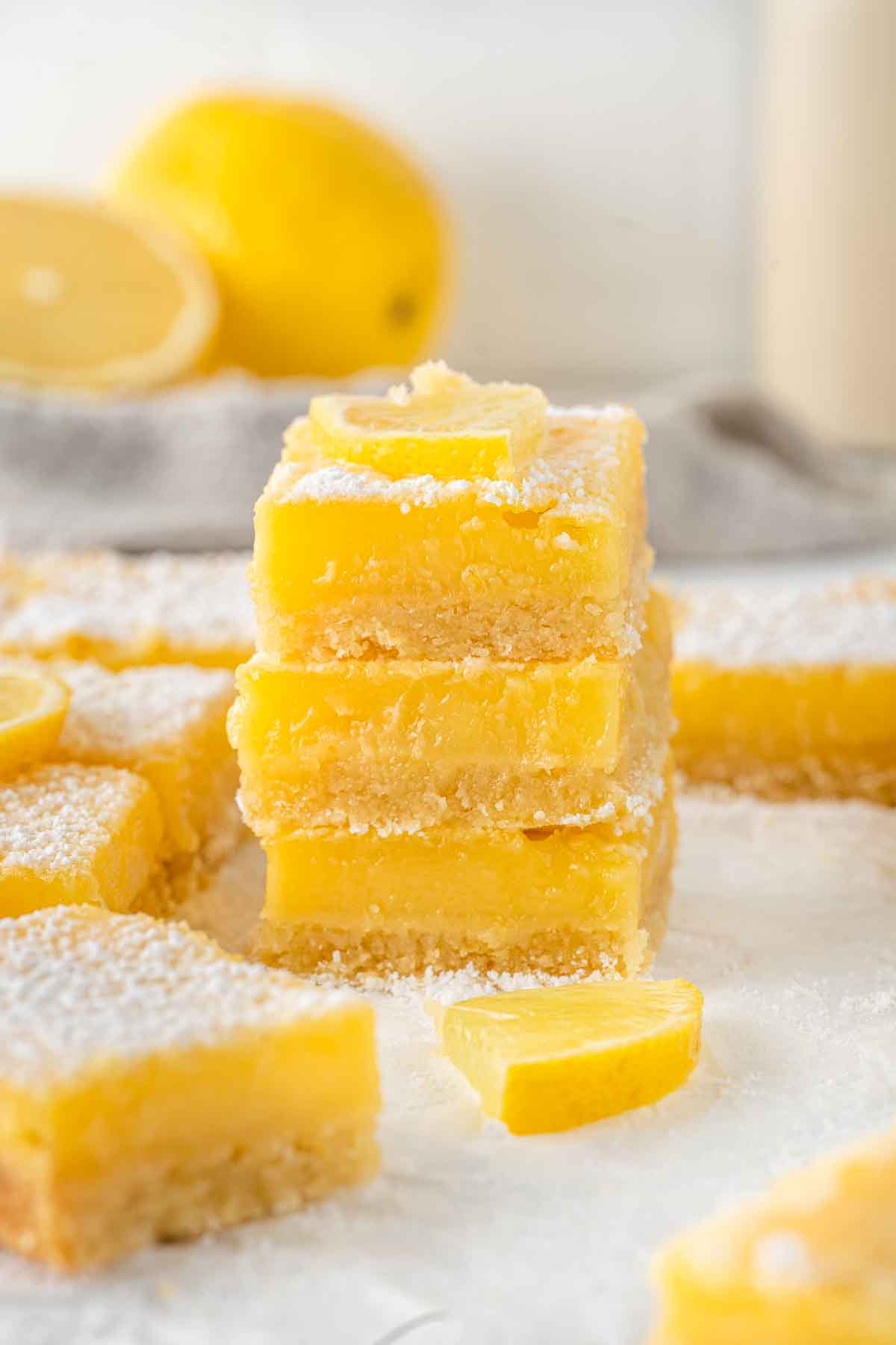 Three dairy free lemon squares stacked together.
