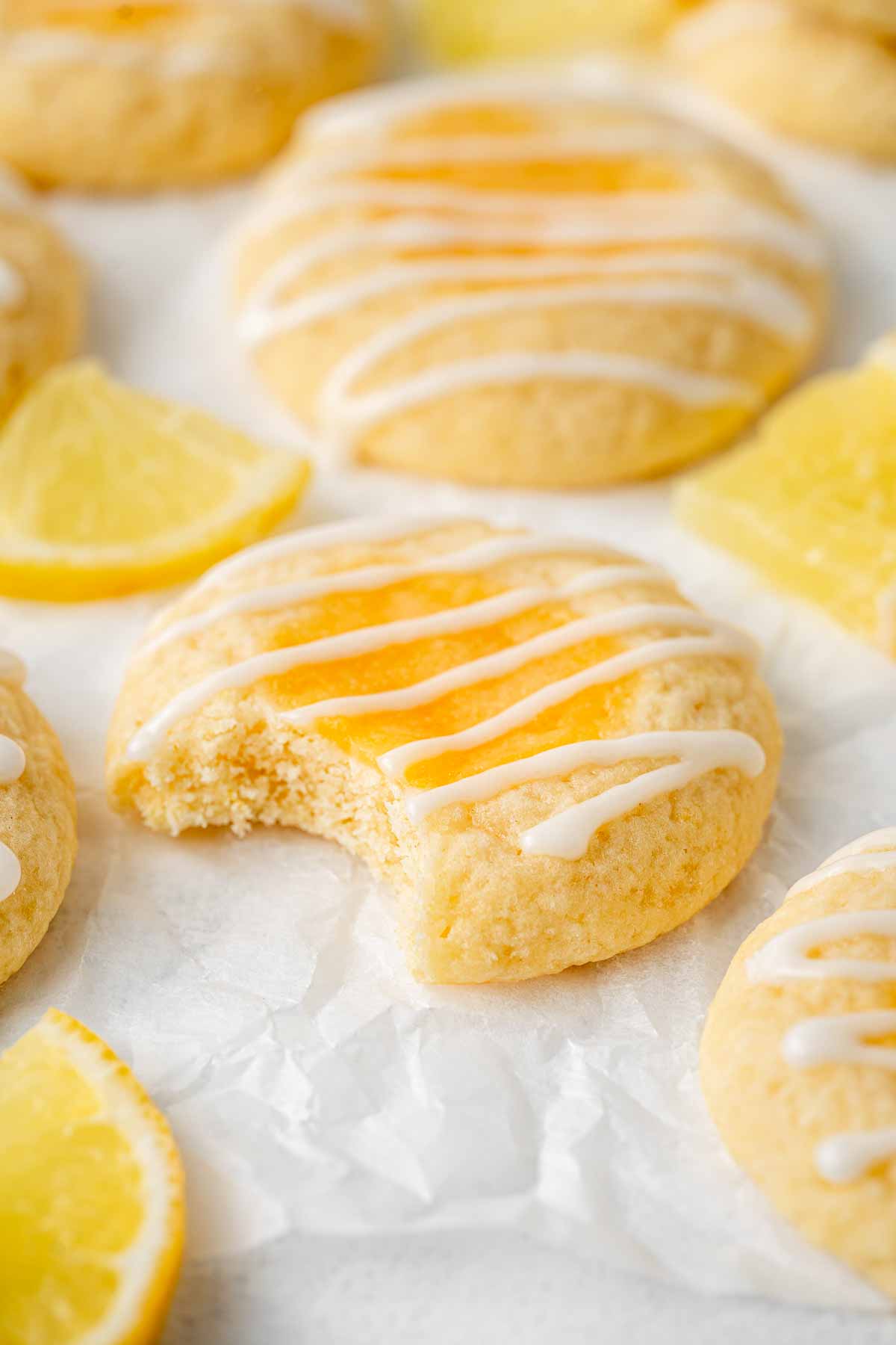 Close up of a single lemon thumbprint cookie with a bite taken.