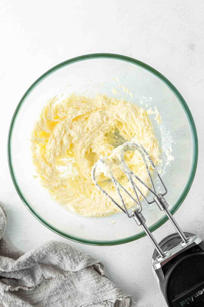 Beating together the butter and sugar in a mixing bowl.