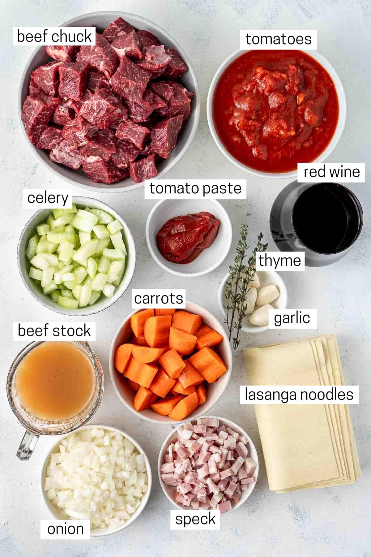 All ingredients needed to make beef ragu laid out in bowls.