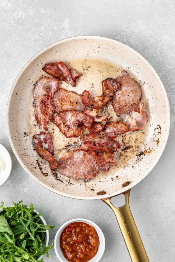 Frying crispy bacon in a pan.