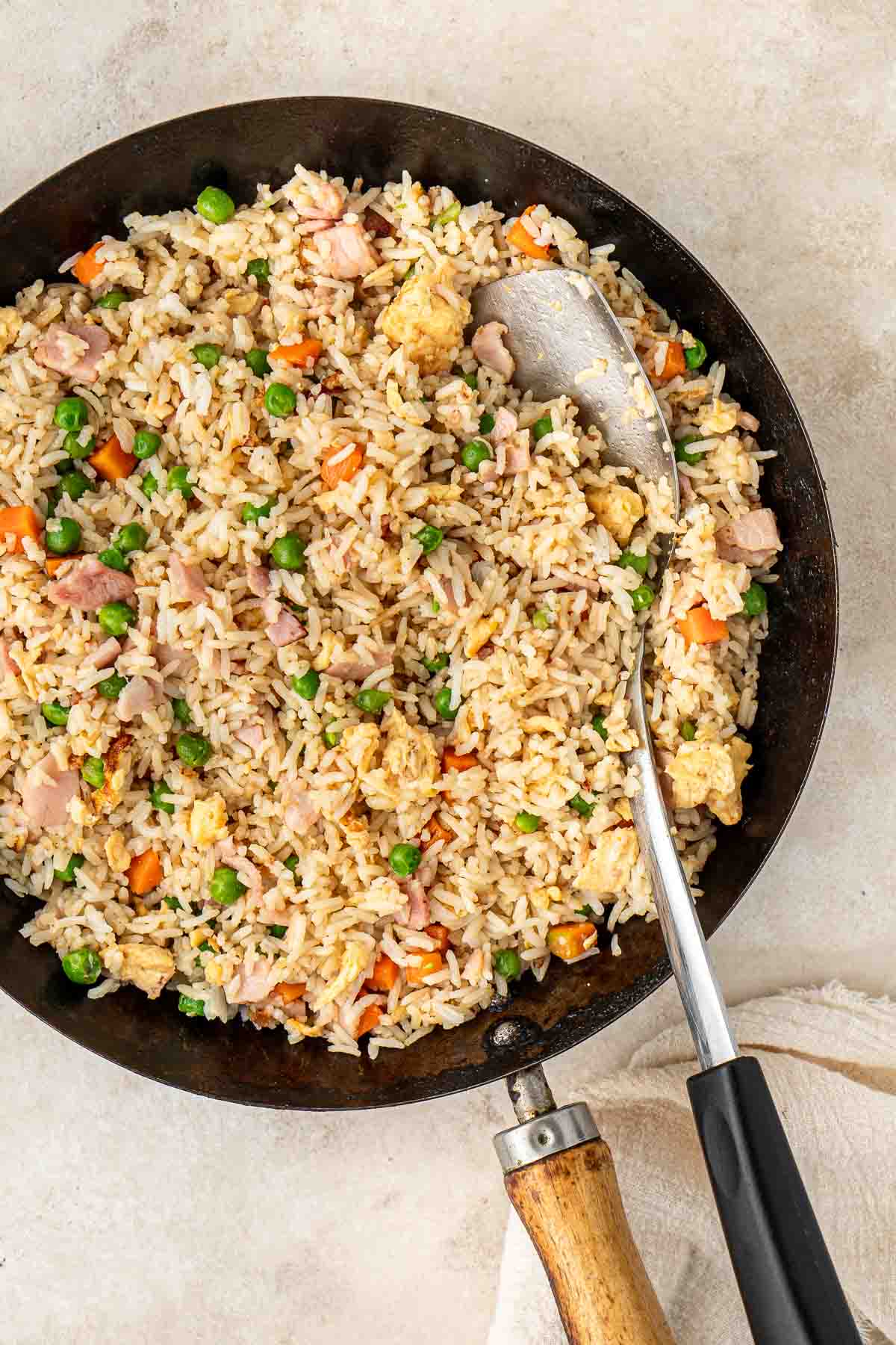 Fried rice in a wok with a wok spatula. 