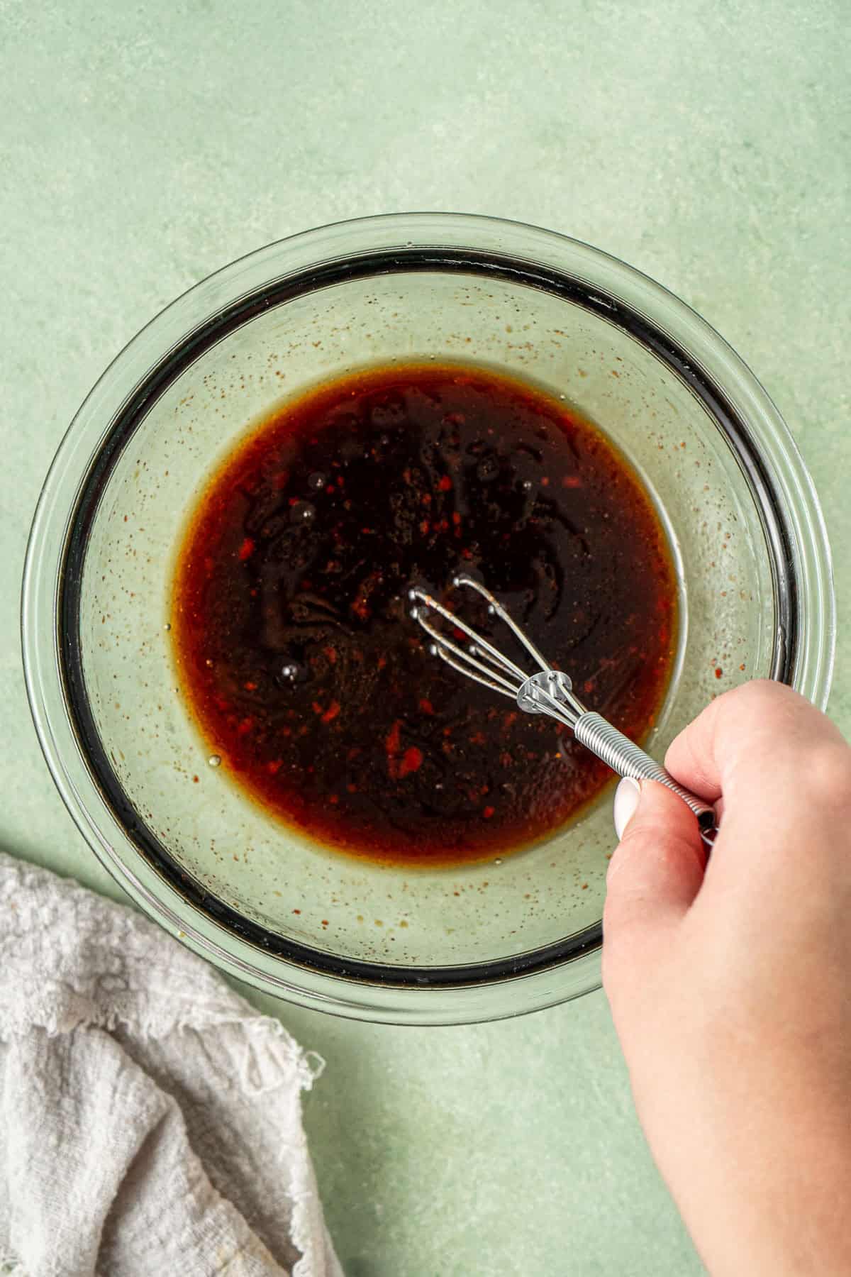 Mixing together the sauce ingredients in a small glass bowl.