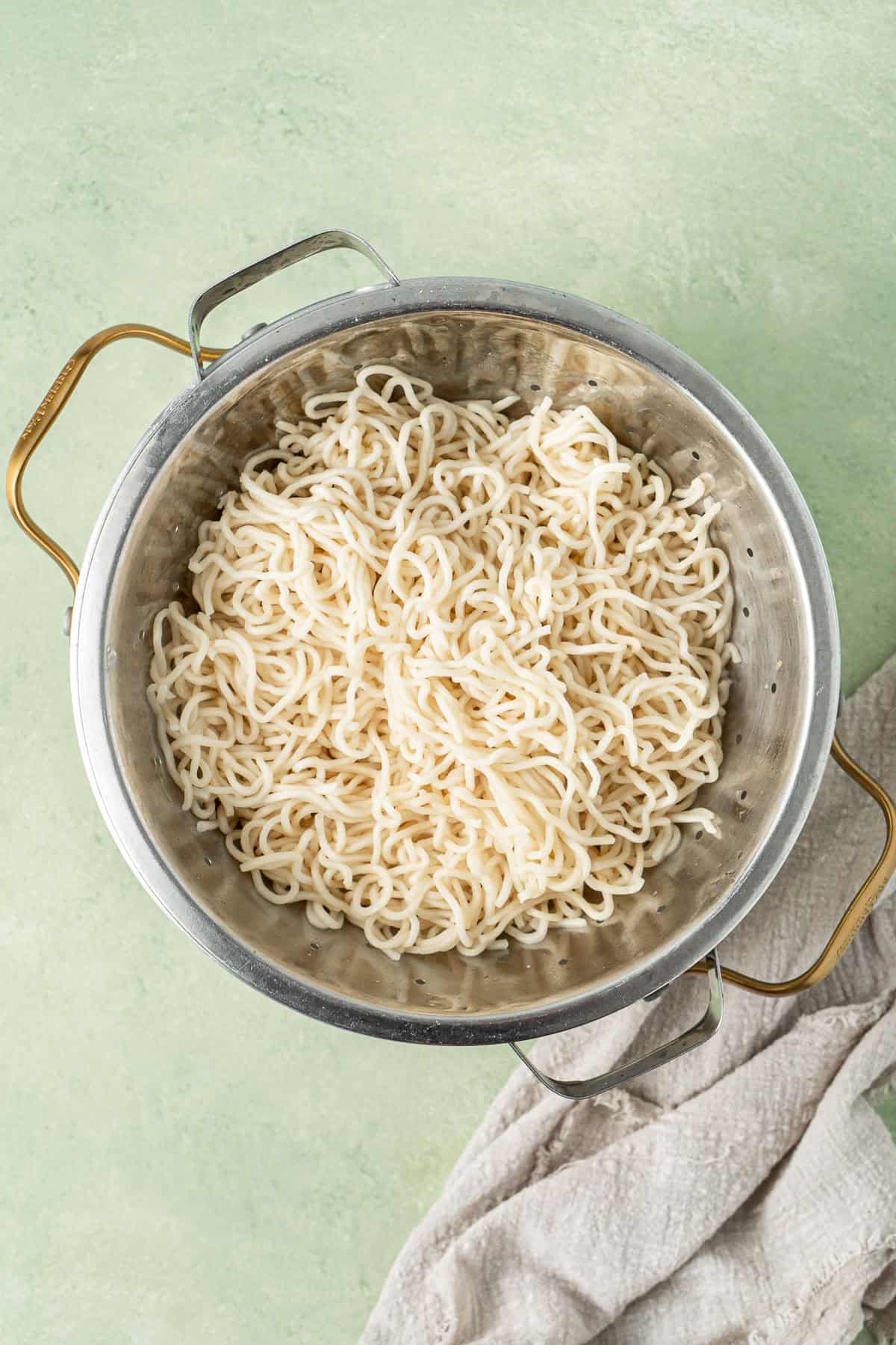 The cooked and drained noodles in a colander. 