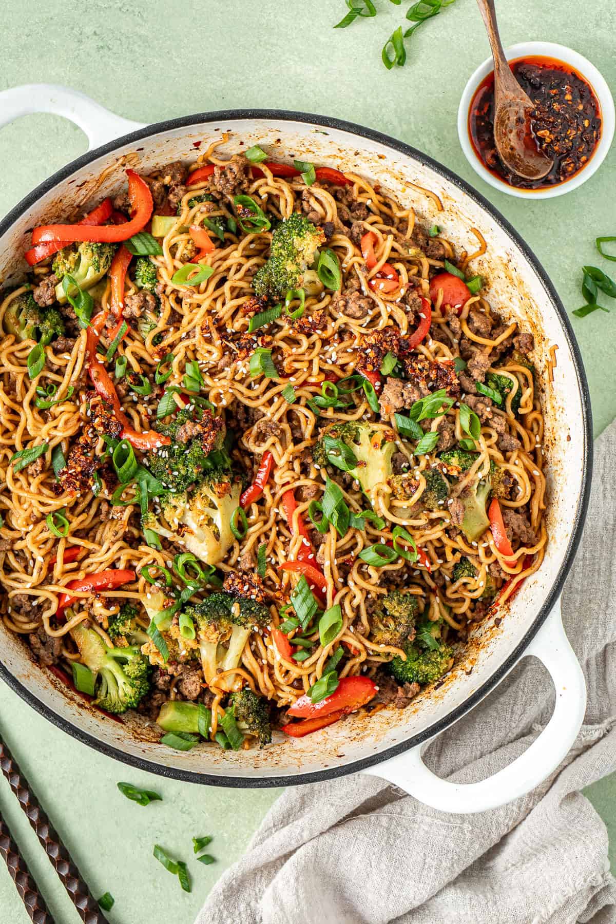The finished noodles in the pan topped with spring onion.