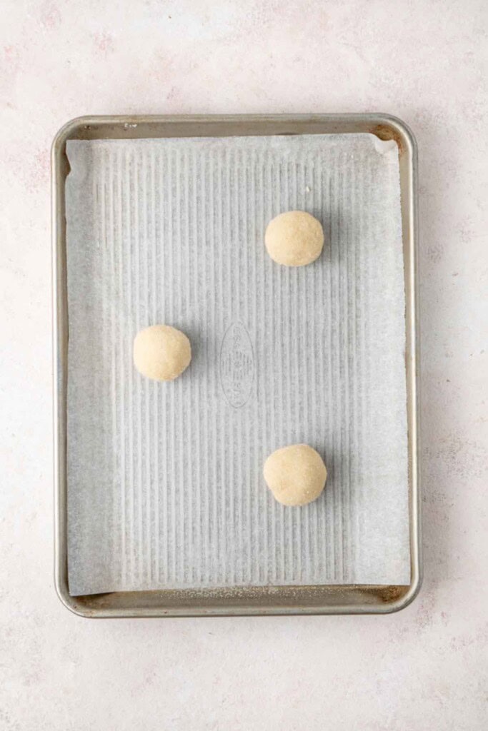 Balls of cookie dough on a baking tray.
