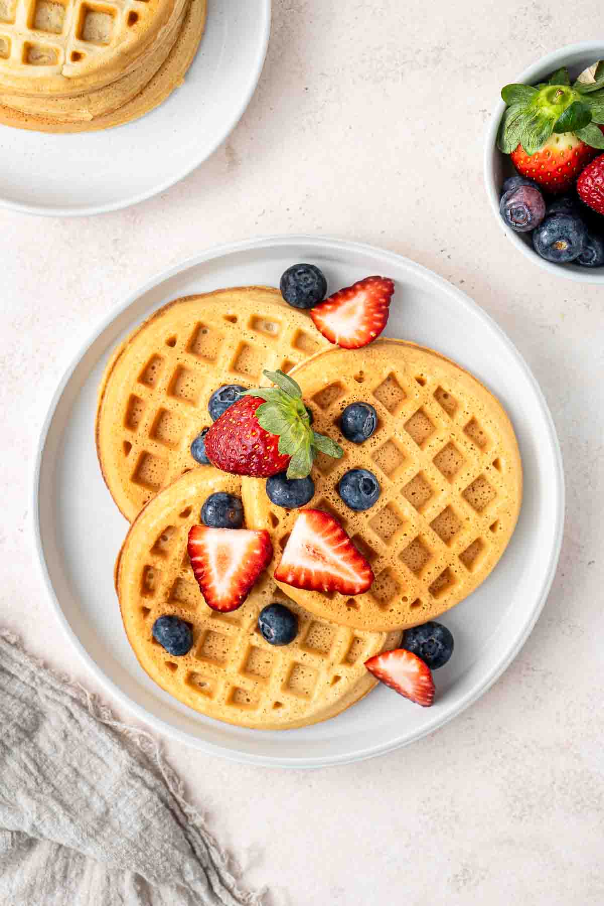 Dairy free waffles served on a plate with fresh berries.