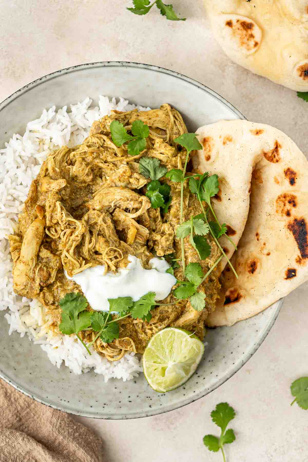 Coconut chicken curry and rice with naan in a bowl.