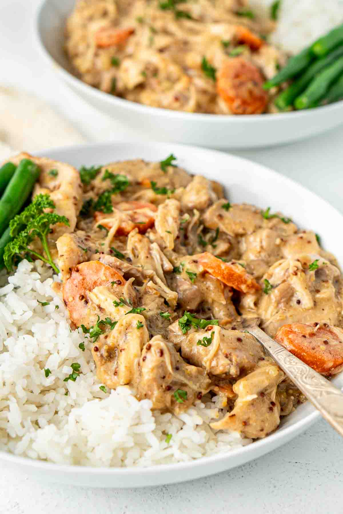 Close up of honey mustard chicken served in a bowl with a fork.