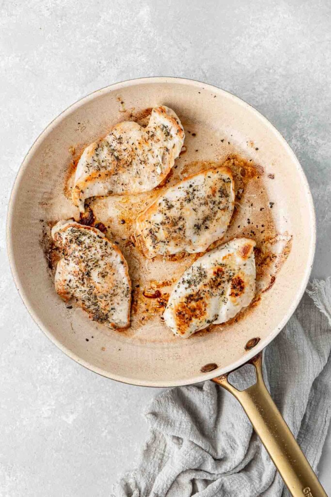 Grilling chicken in a frying pan.