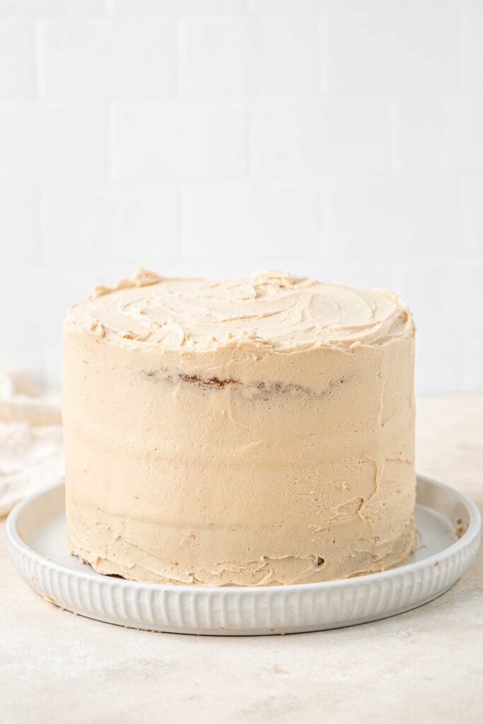 Frosting the cake with vegan biscoff buttercream.