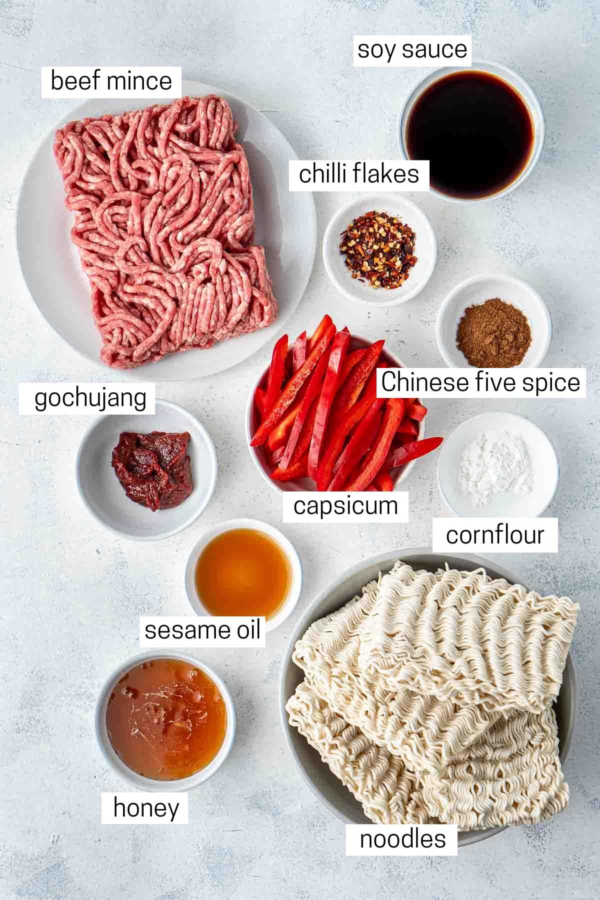 All ingredients needed to make chilli beef noodles laid out in bowls.