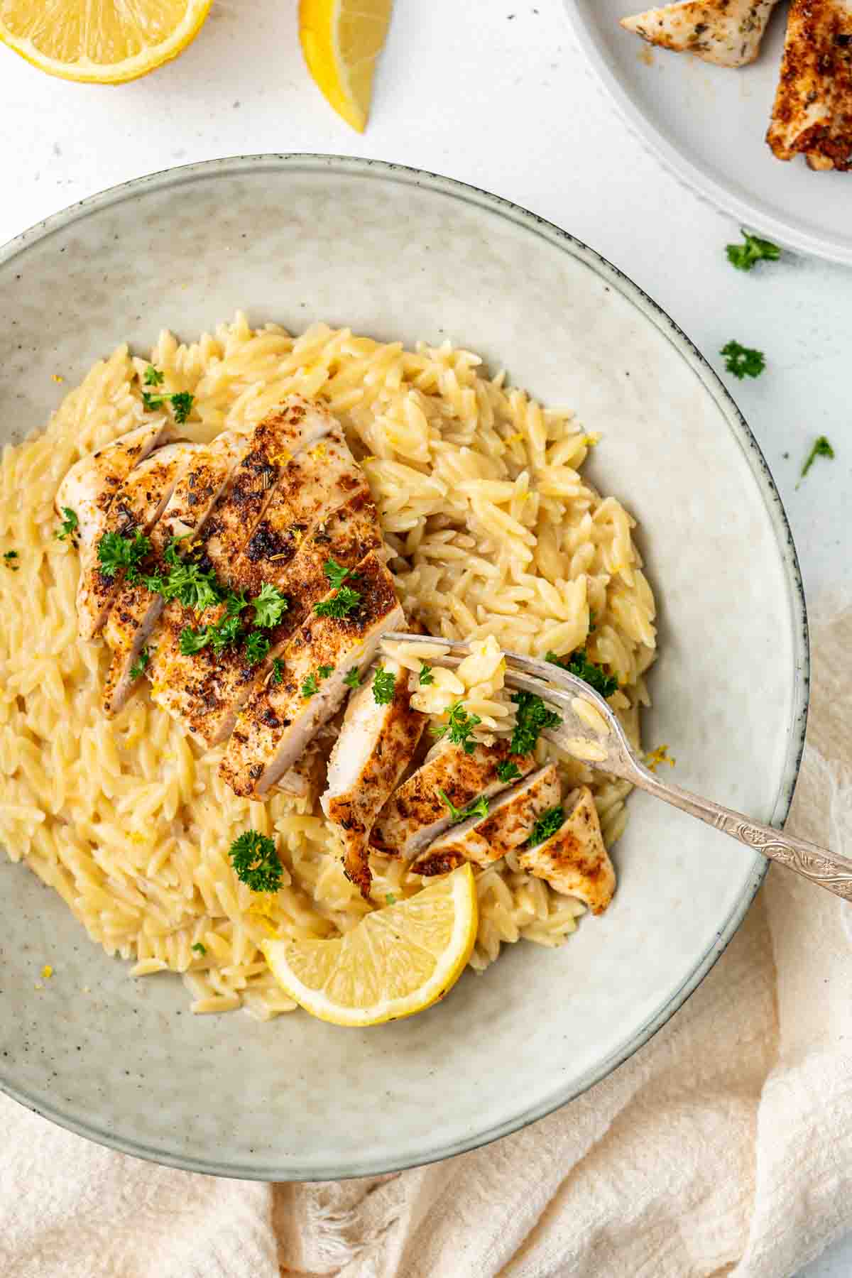 Lemon risoni with grilled chicken in a bowl.