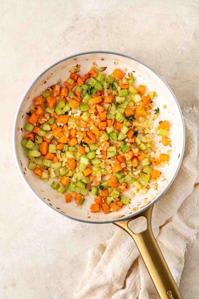 Sautéing the vegetables for chicken pot pie in a frying pan.