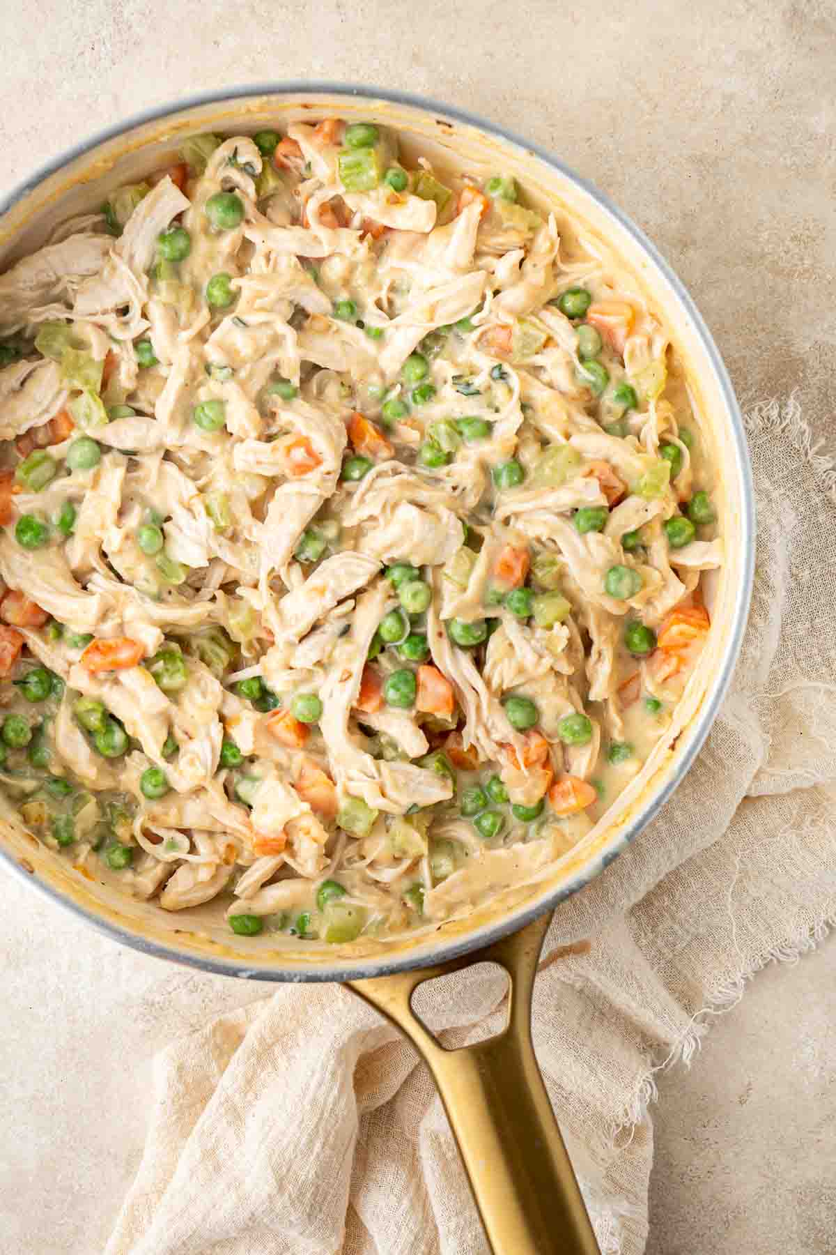 The chicken pot pie filling in a frying pan.