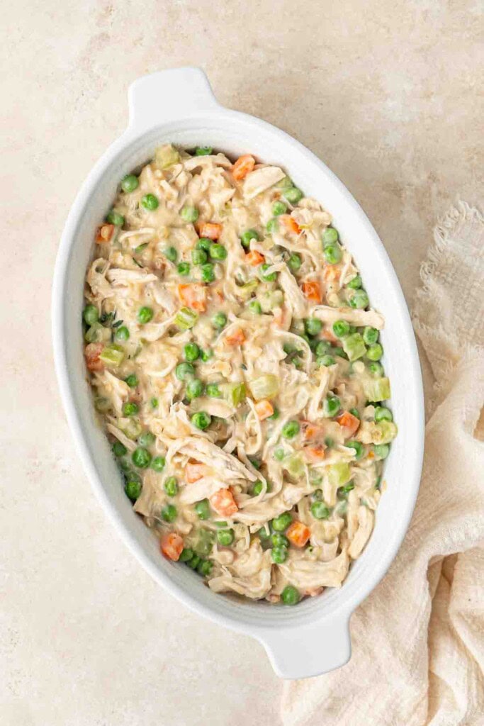 The creamy chicken pie filling in a pie dish.