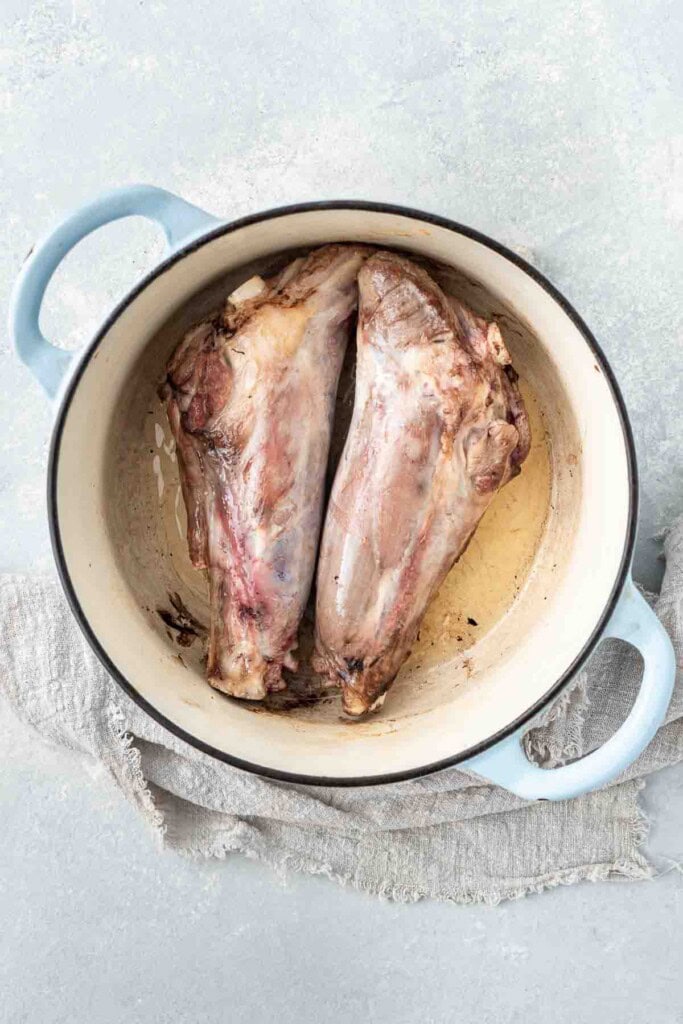 Browning the lamb shanks in a large pot.