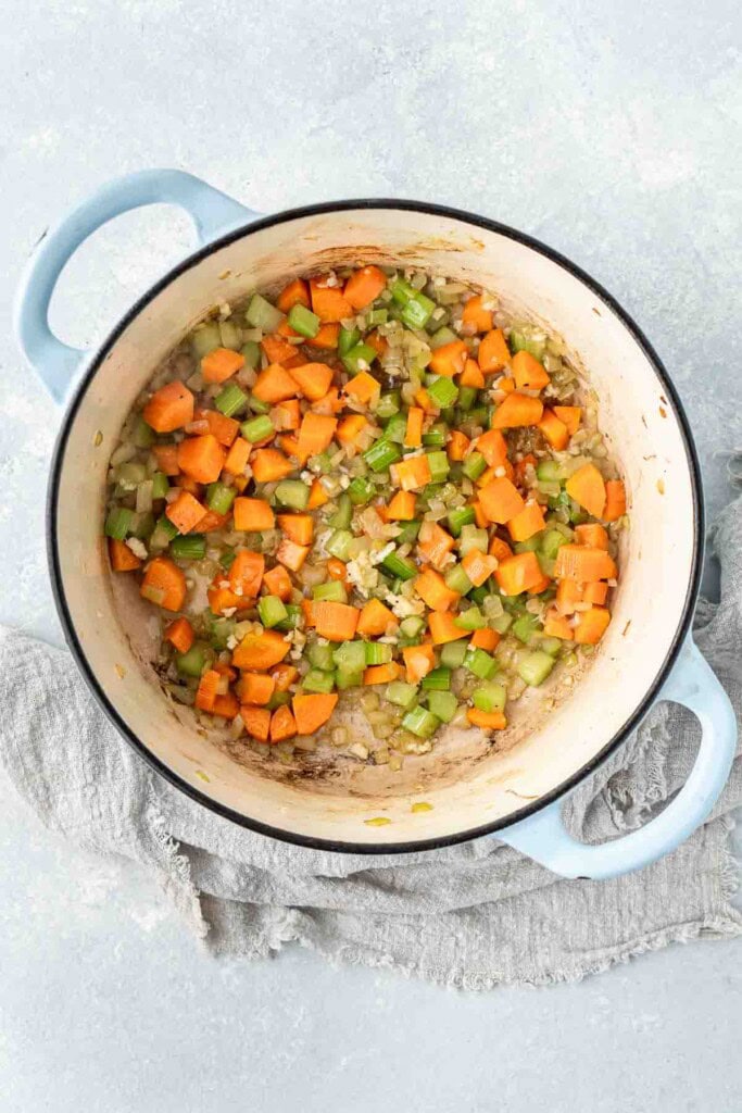 Sautéing the vegetables in a large pot.