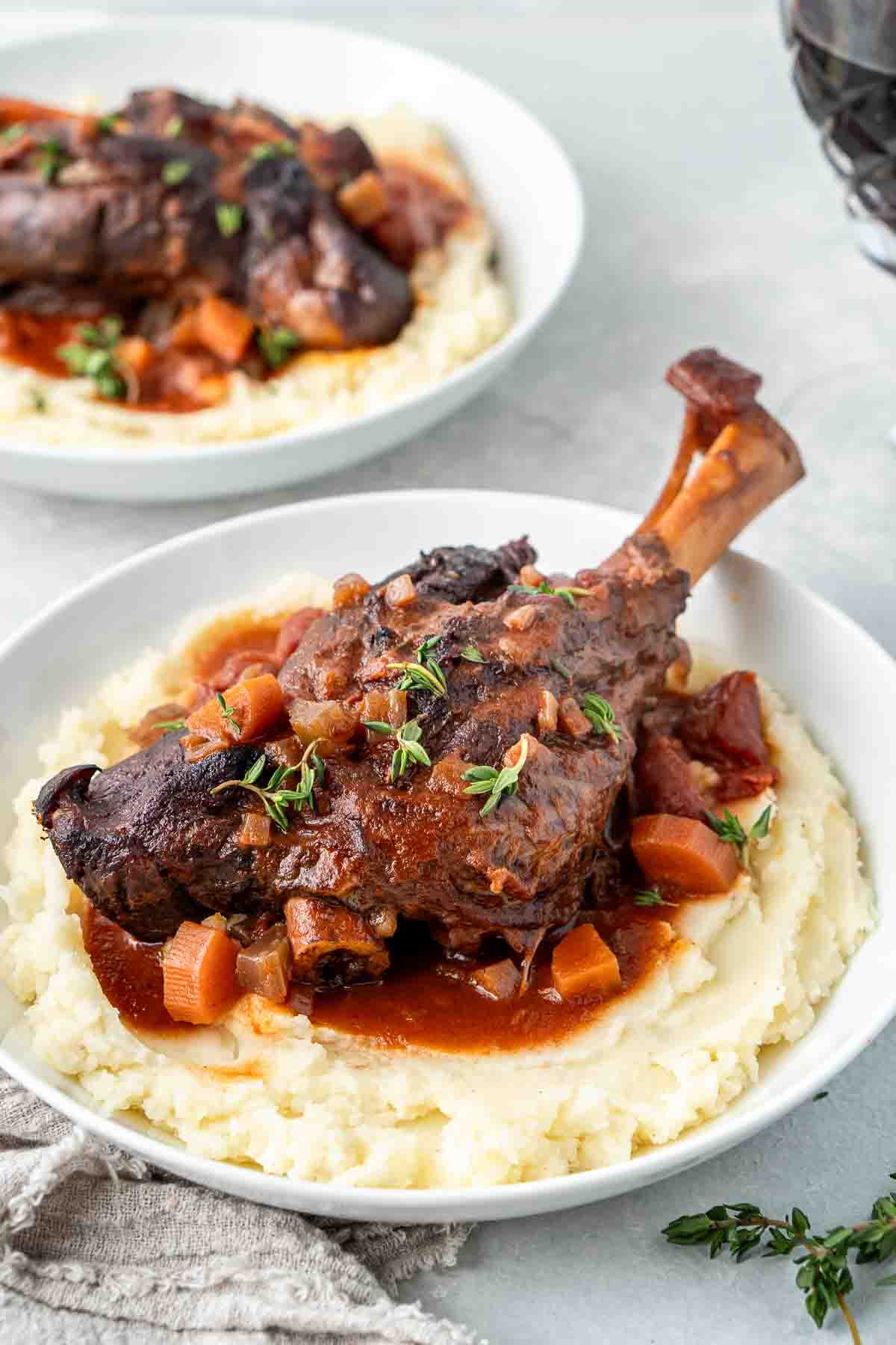 Braised lamb shanks served over a bed of mashed potato. 