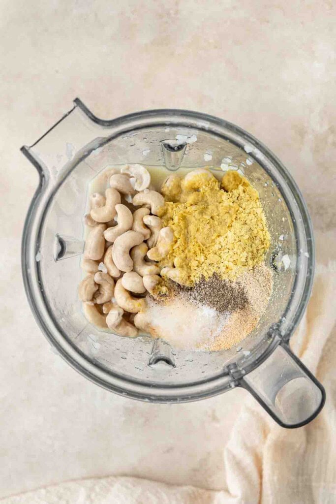 All ingredients to make the alfredo sauce in a blender.