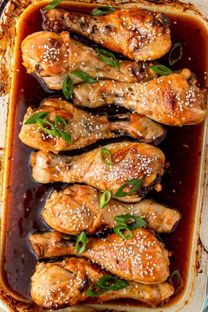 Chicken drumsticks with spring onion and sesame seeds.