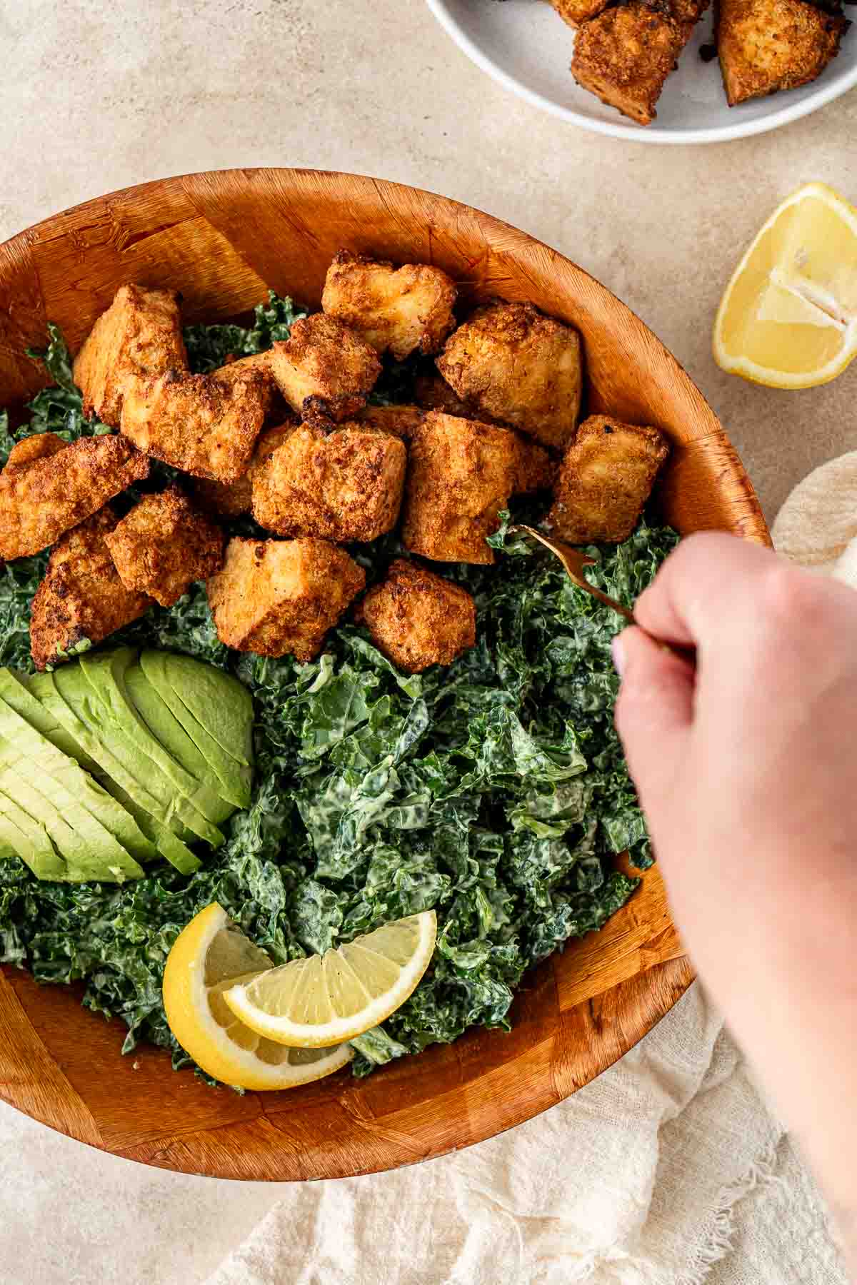 A big bowl of kale salad with lemon, avocado and air fried tofu.