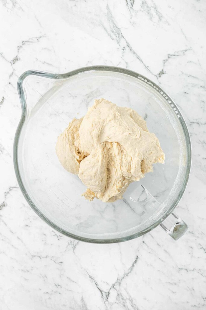 Mixing up the pizza dough in a glass bowl.