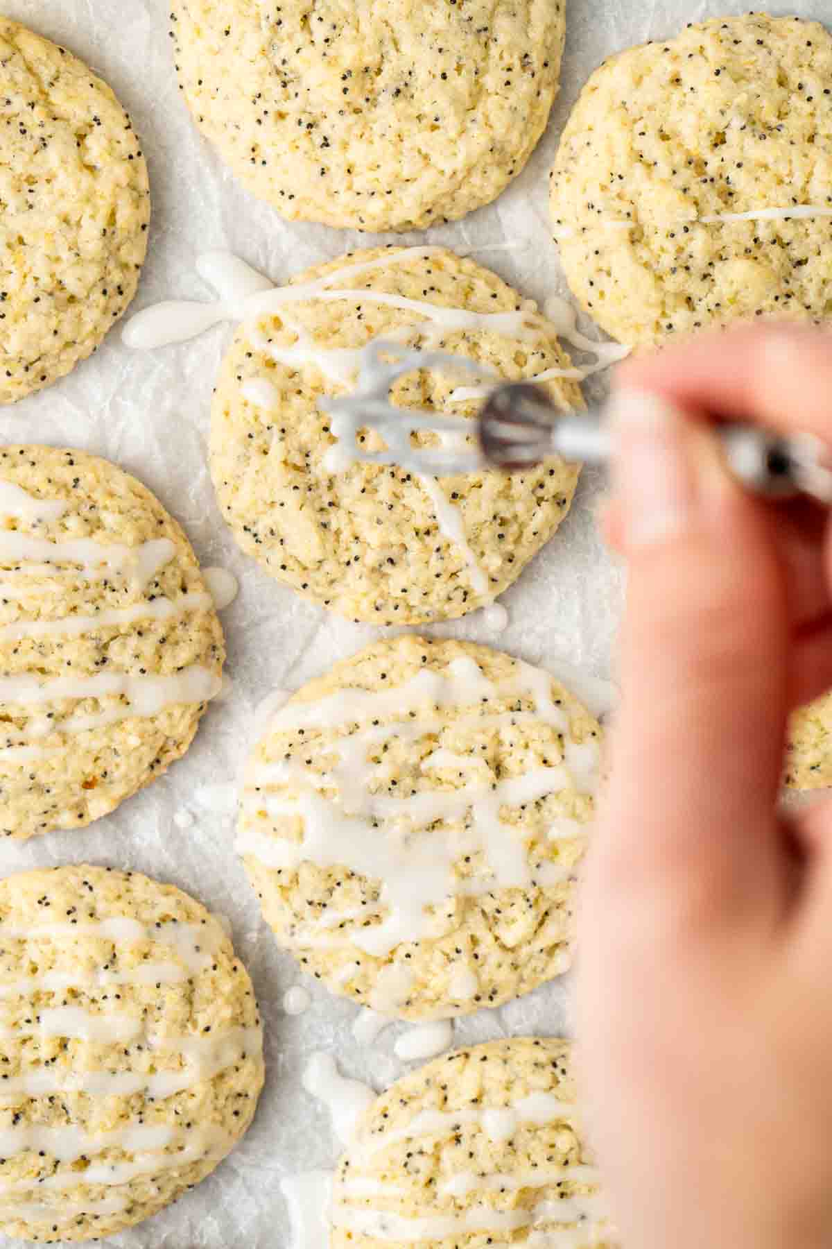 Drizzling a lemon glaze over lemon poppy seed cookies.