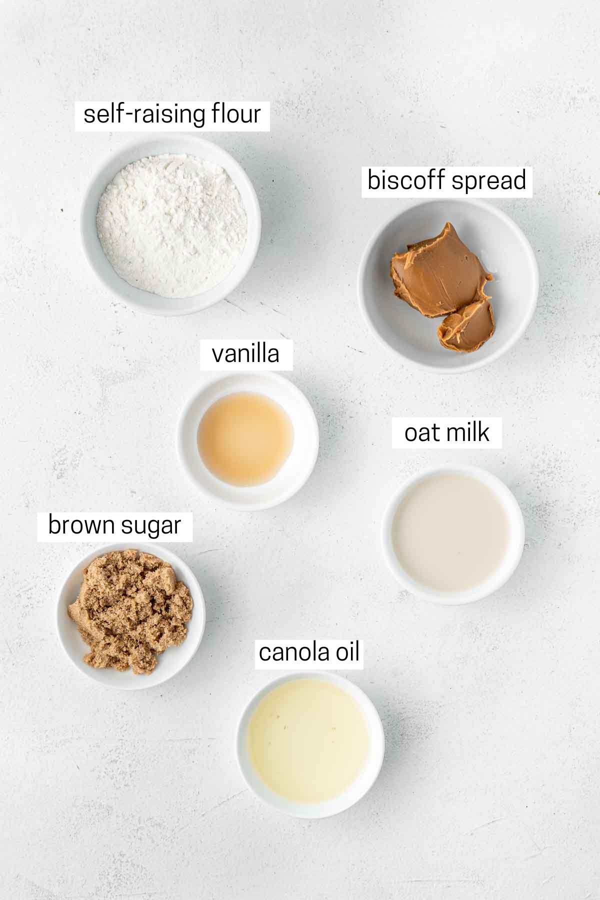 All ingredients needed to make a biscoff mug cake laid out in small bowls.