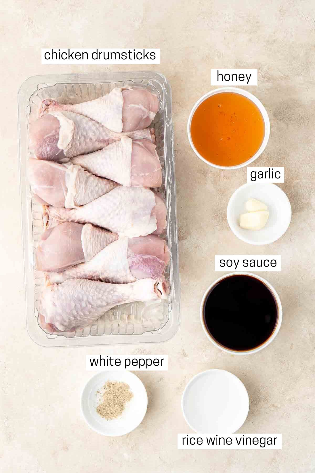 All ingredients needed to make honey soy chicken drumsticks laid out in bowls.