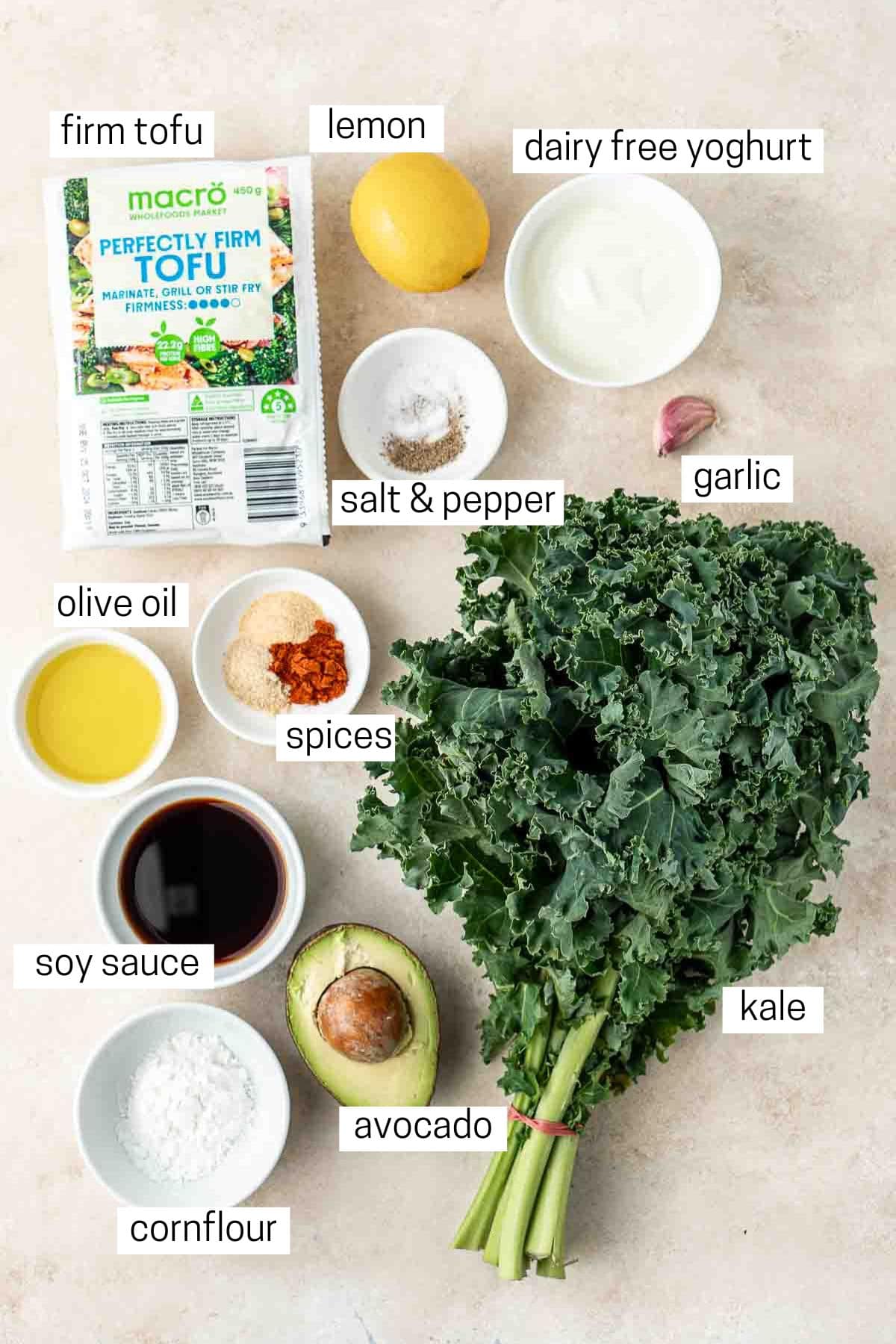 All ingredients needed to make kale salad with tofu laid out in bowls.