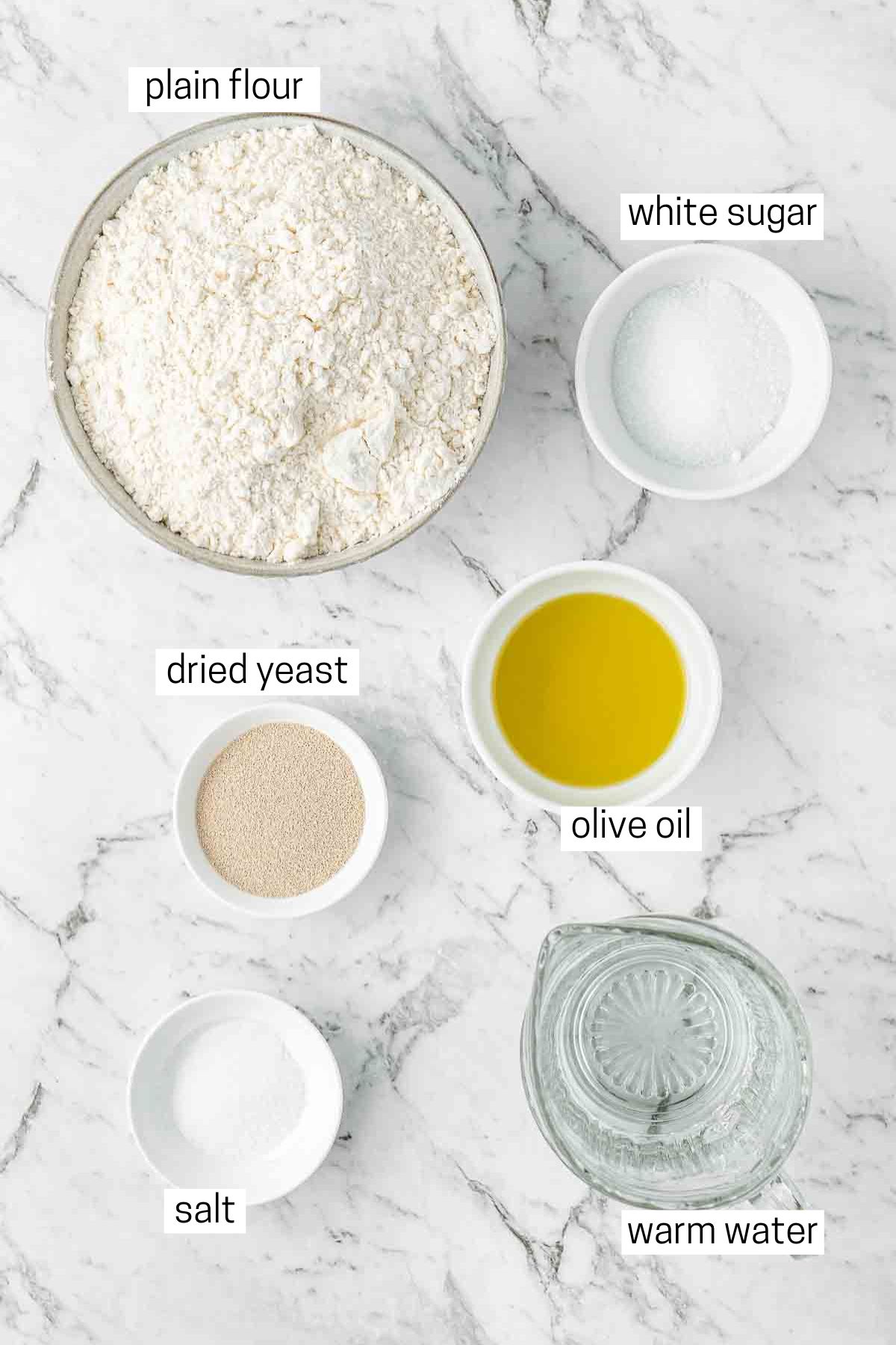 All ingredients needed to make pizza dough laid out in small bowls.