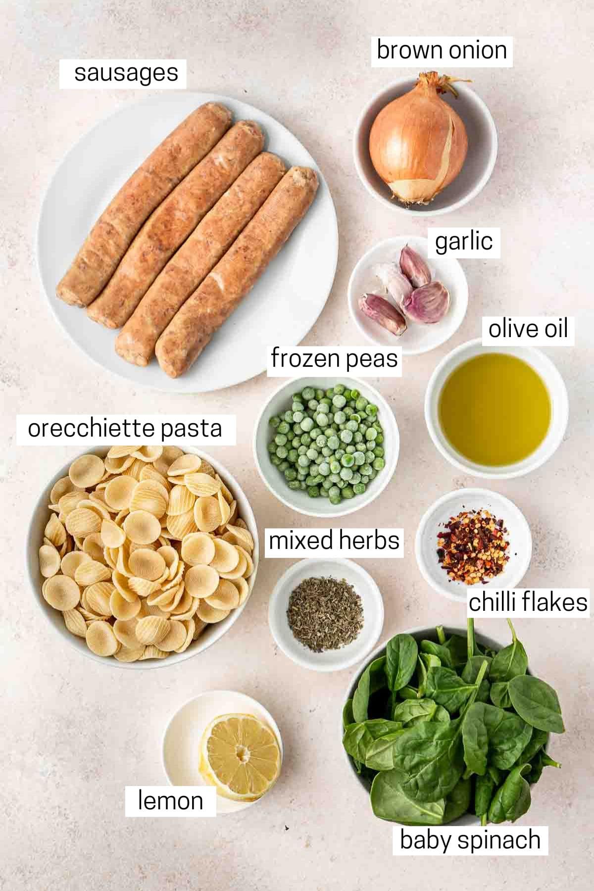 All ingredients needed for sausage and spinach orecchiette laid out in bowls.